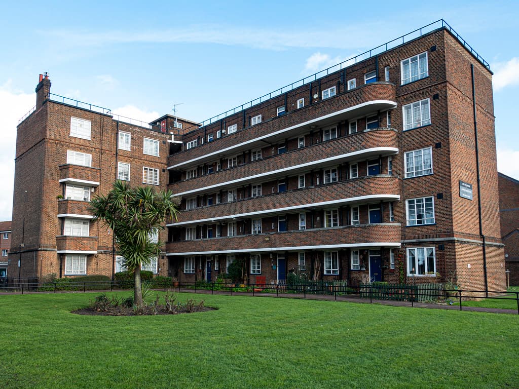 A five-storey brick social housing block with curved balconies and landscaped lawns at Avondale Square Estate, Old Kent Road, London.