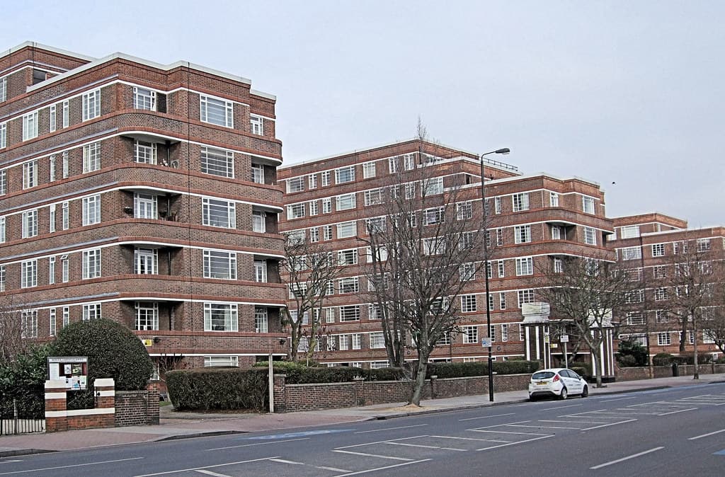 A large brick mansion block of residential flats on a street in Balham, south London